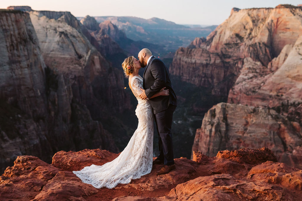 bride and groom kiss on cliffside during elopement