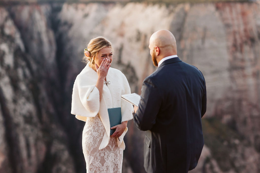 bride wipes tears away from her eyes as groom talks