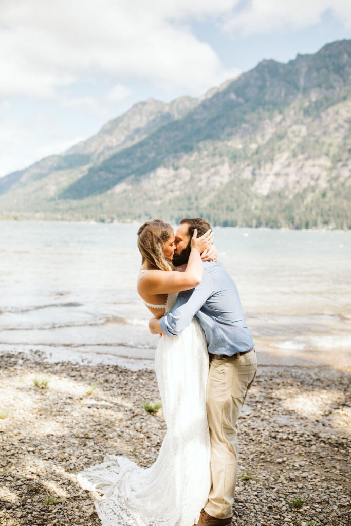 bride and groom kiss in front of lake wenatchee