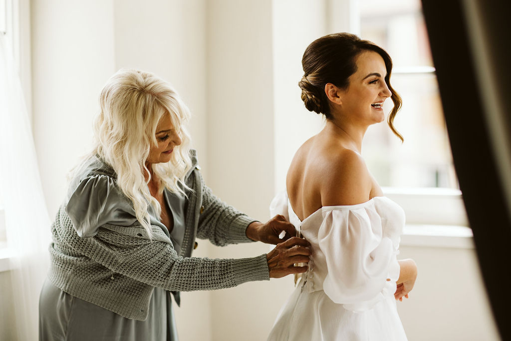bride's mom does up her dress