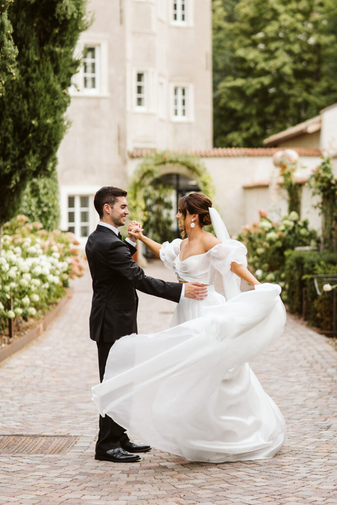 bride spins her dress in front of castle