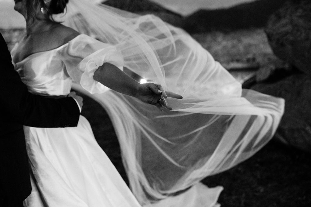 bride holds out veil
