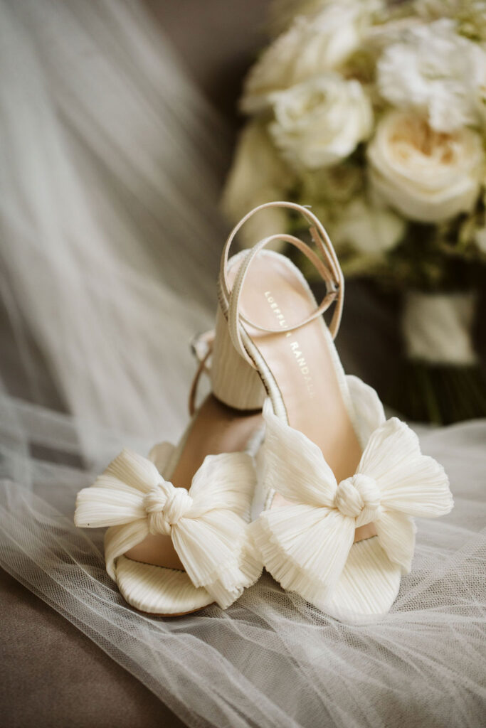 shoes on a veil with flowers in the background