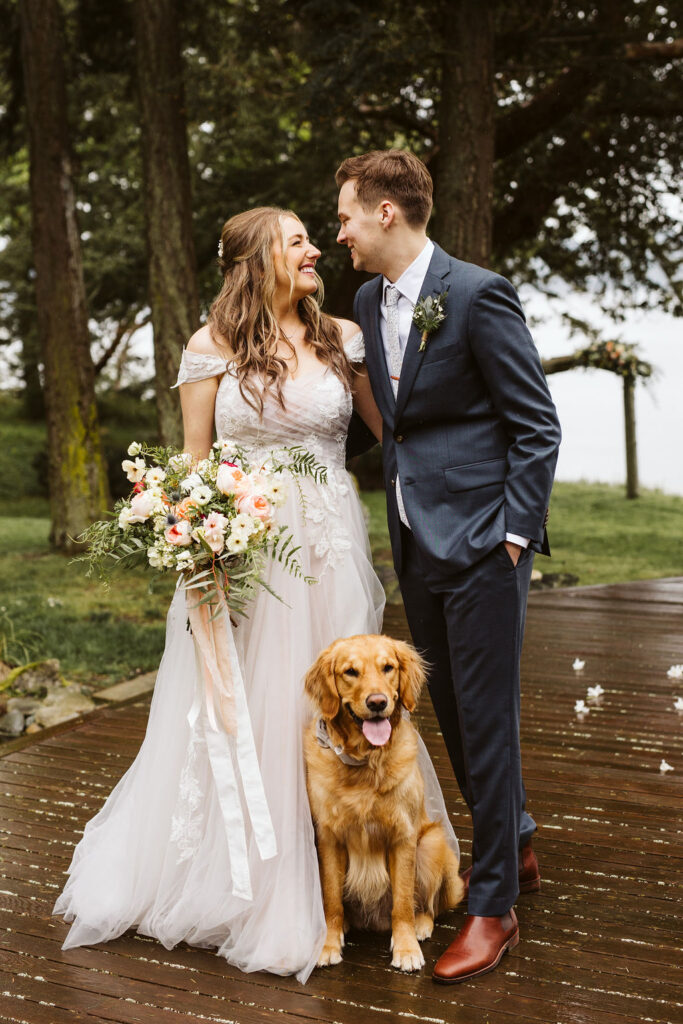 bride and groom pose with their puppy