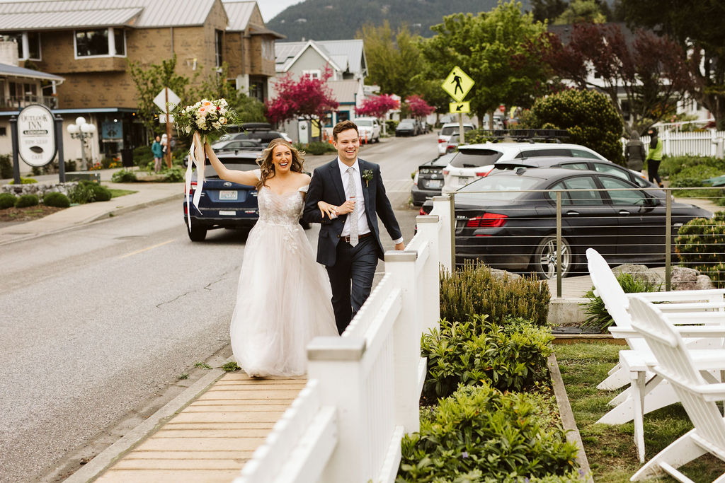 bride and groom walk up sidewalk celebrating