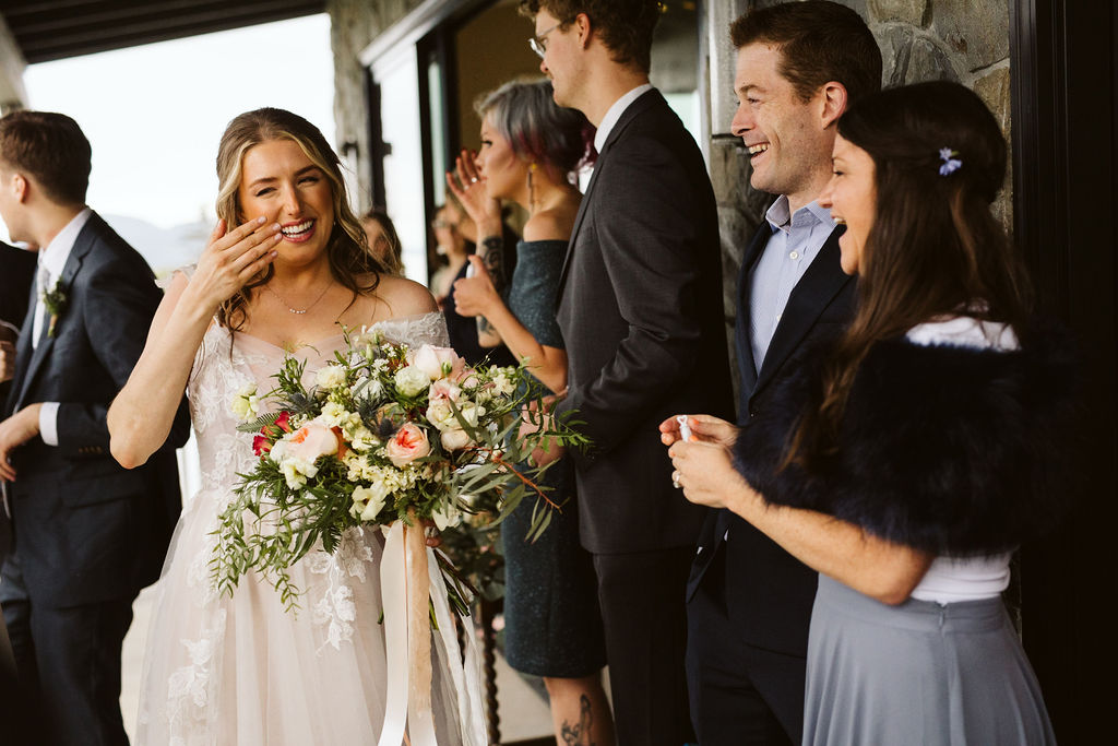 bride wipes a tear away as she talks to guests