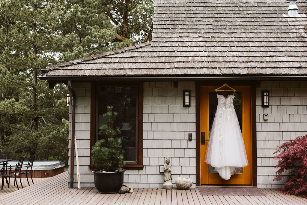 wedding dress hangs on door outside of house