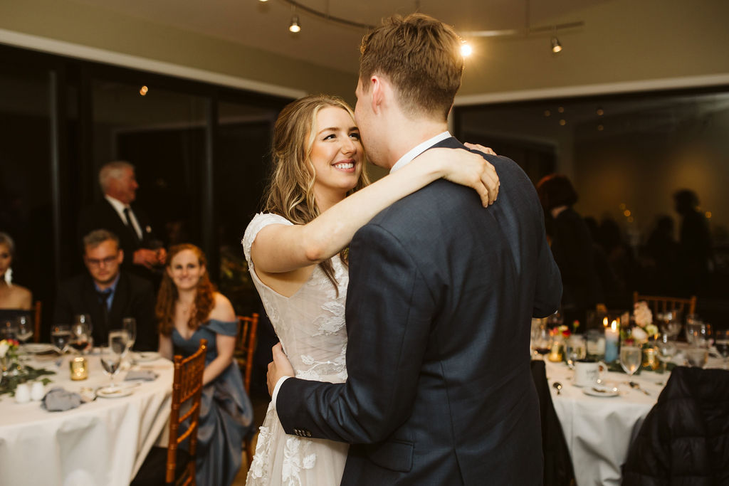 bride smiles at groom as they slow dance