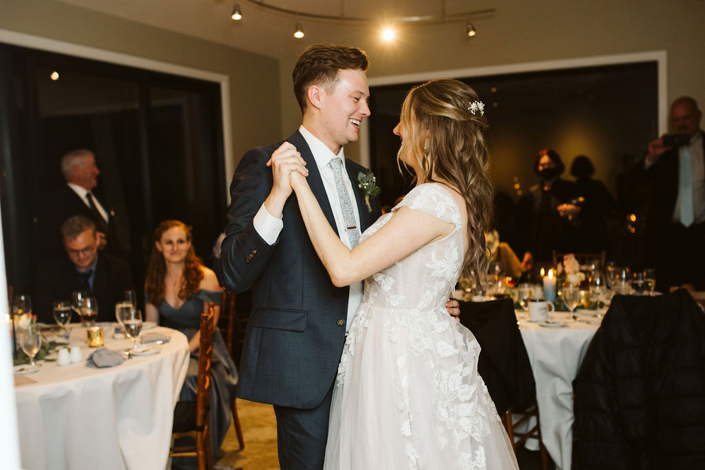 bride and groom smile at each other as they slow dance