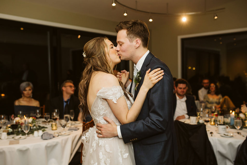 bride and groom kiss during slow dance