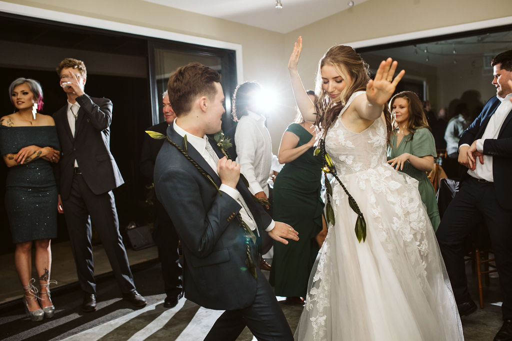 bride and groom dance together with their guests