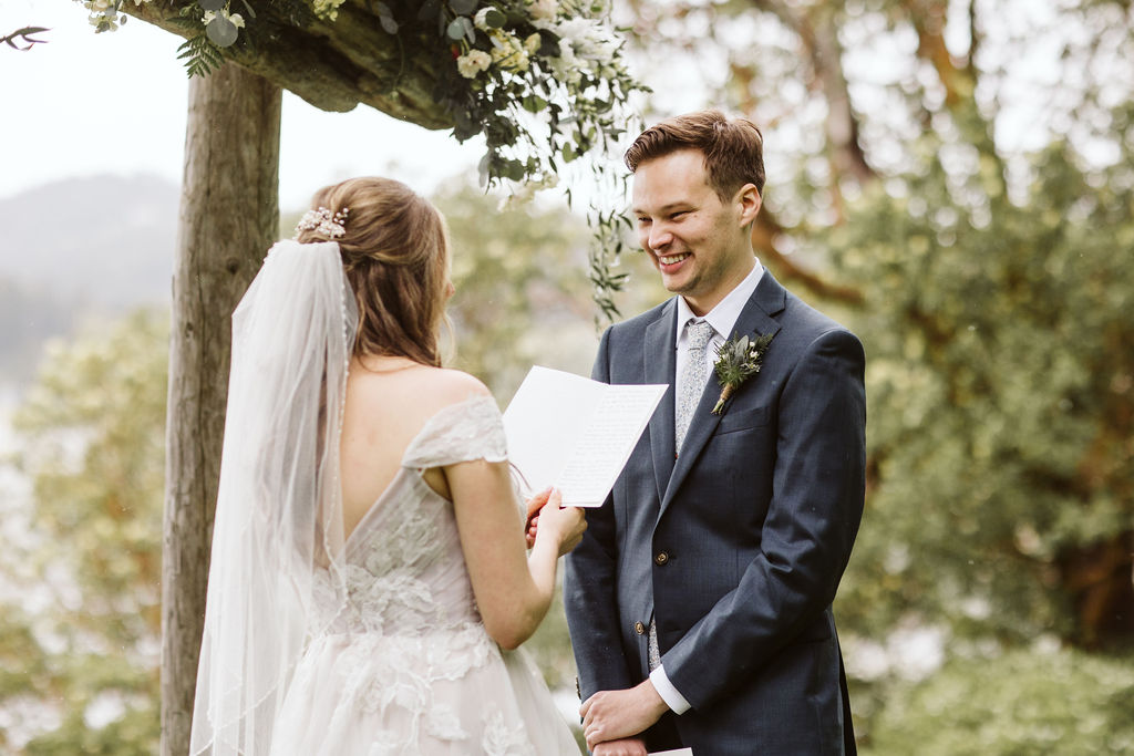 groom smiles at bride during ceremony on orcas island