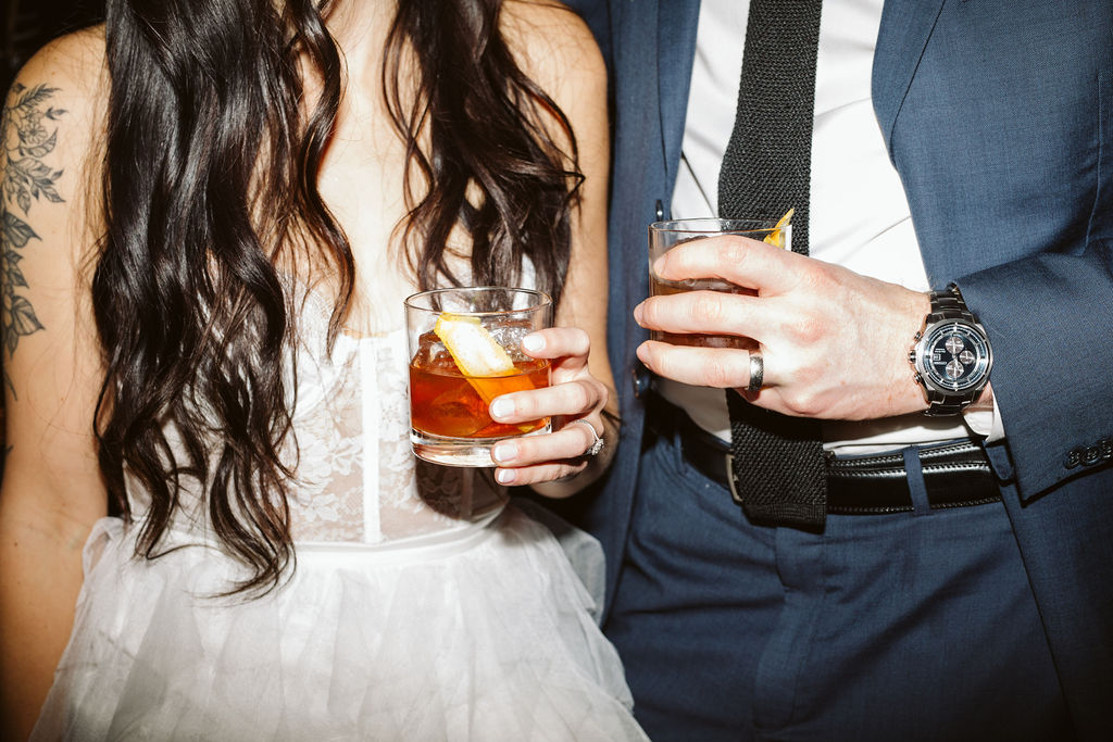 bride and groom hold cocktails