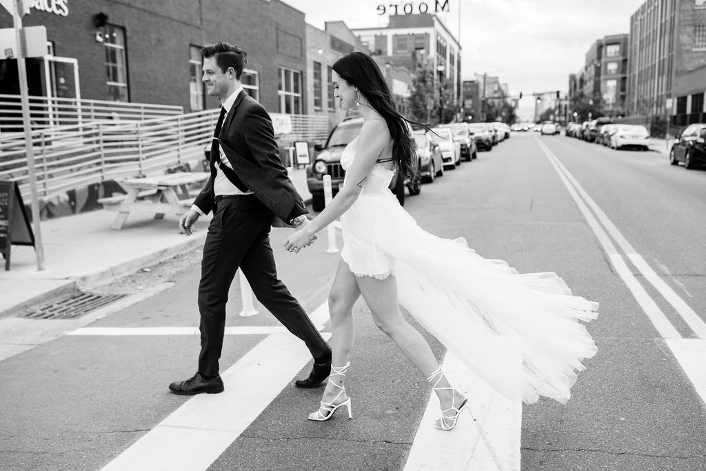 bride and groom walk across the street during modern city elopement