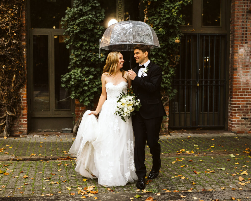 bride and groom post under clear umbrella during pacific northwest elopement