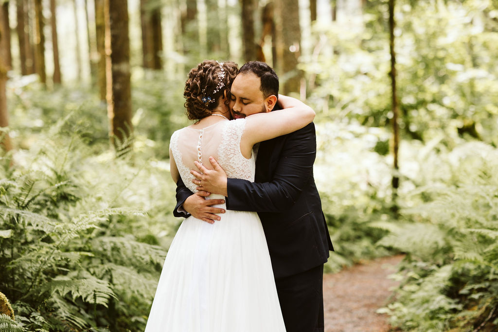 bride and groom hug in forest