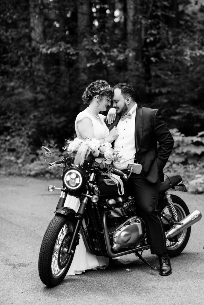 bride and groom sit on a motorcycle to gether