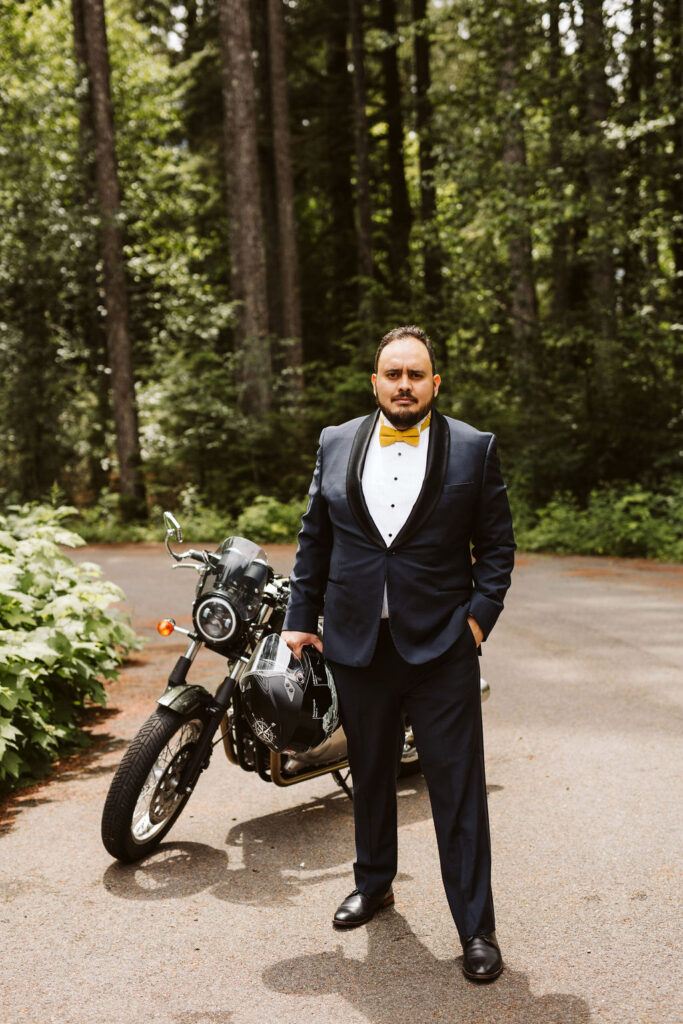 groom stands beside motorcycle