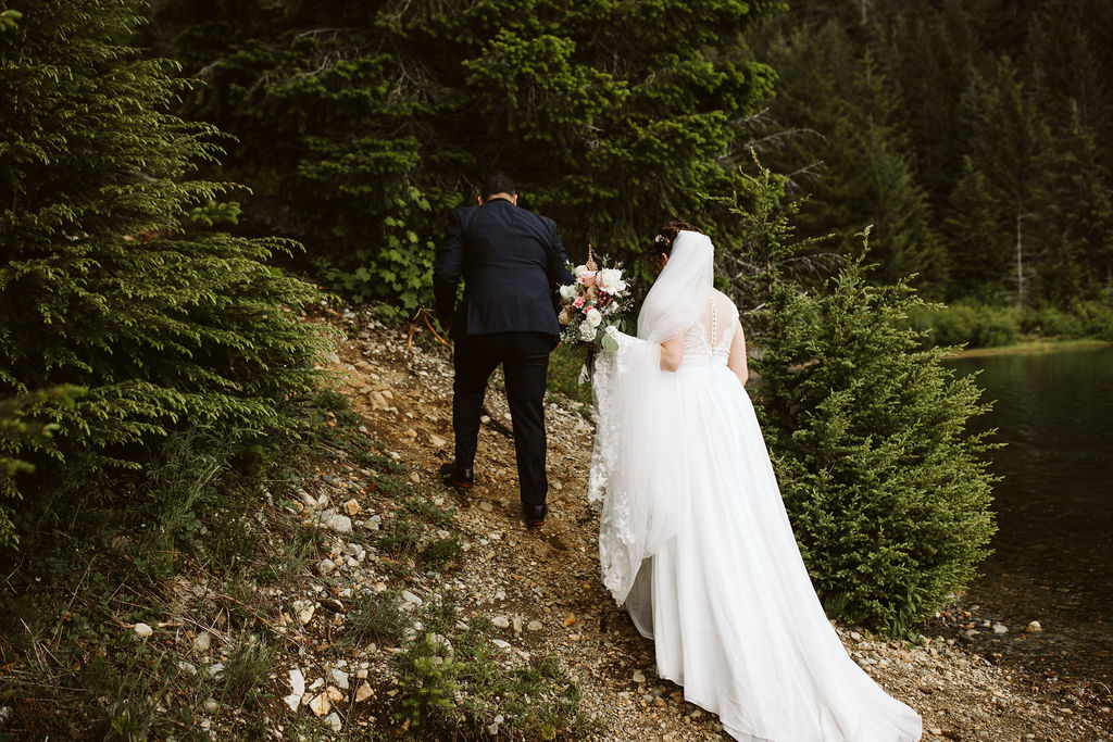 bride and groom walk up hill together