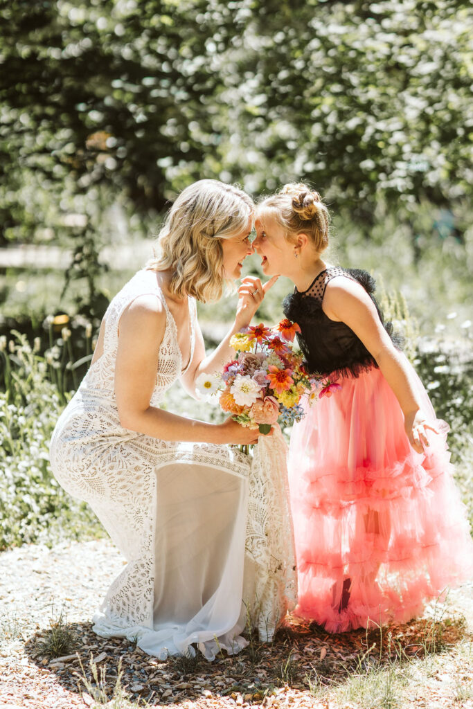 bride and girl in a pink dress touch noses