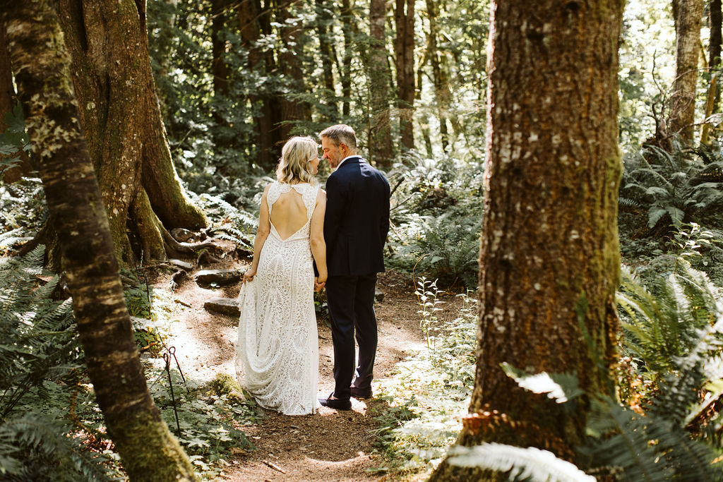 bride and groom kiss in middle of woods