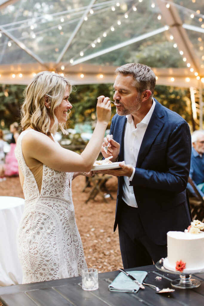 bride and groom feed cake to each other