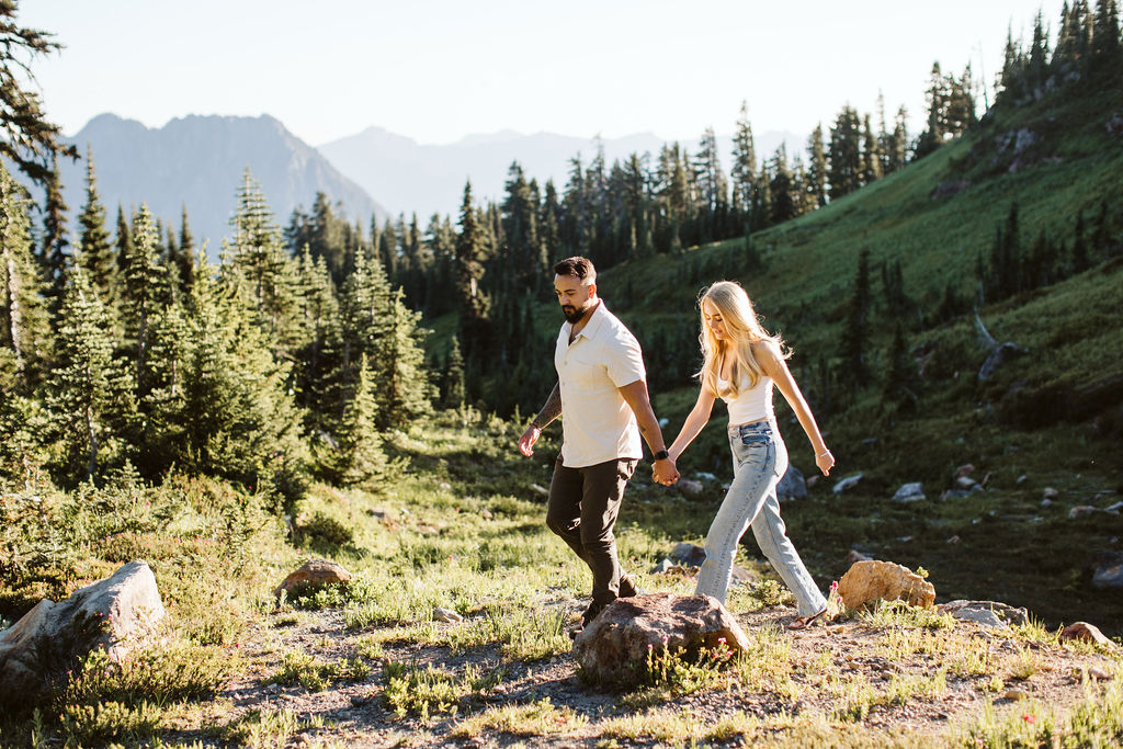girl and boy walk through meadows at mt rainier engagement session