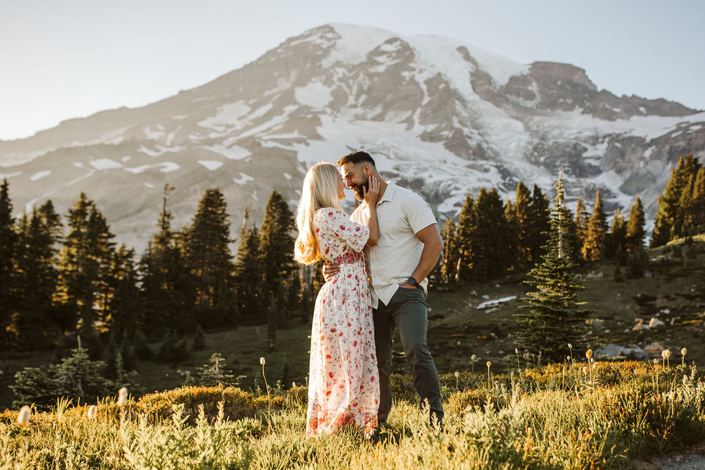 boy and girl kiss in front of mountain at mt rainier engagement session