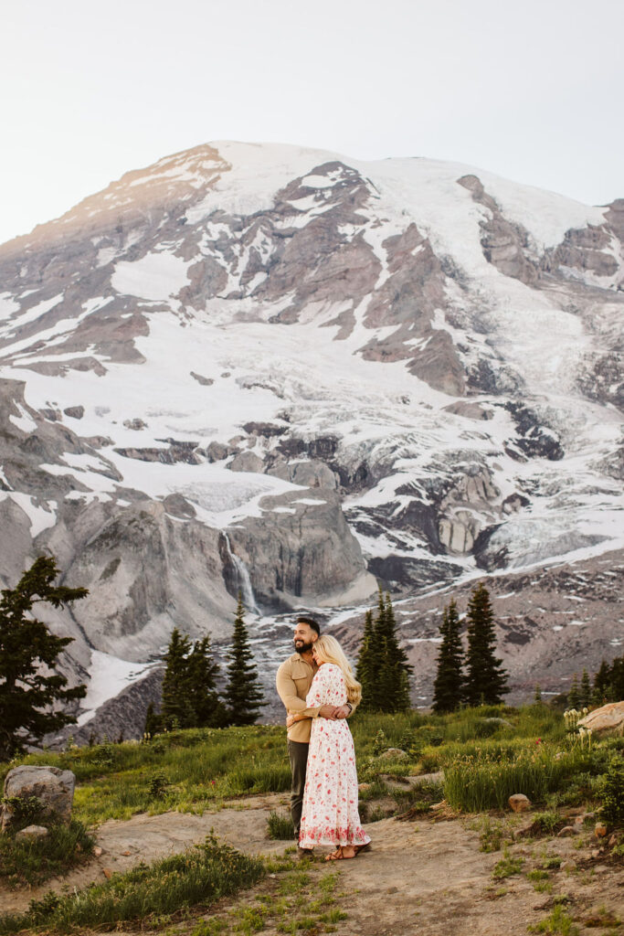 boy and girl hold each other while standing in front of mount rainier