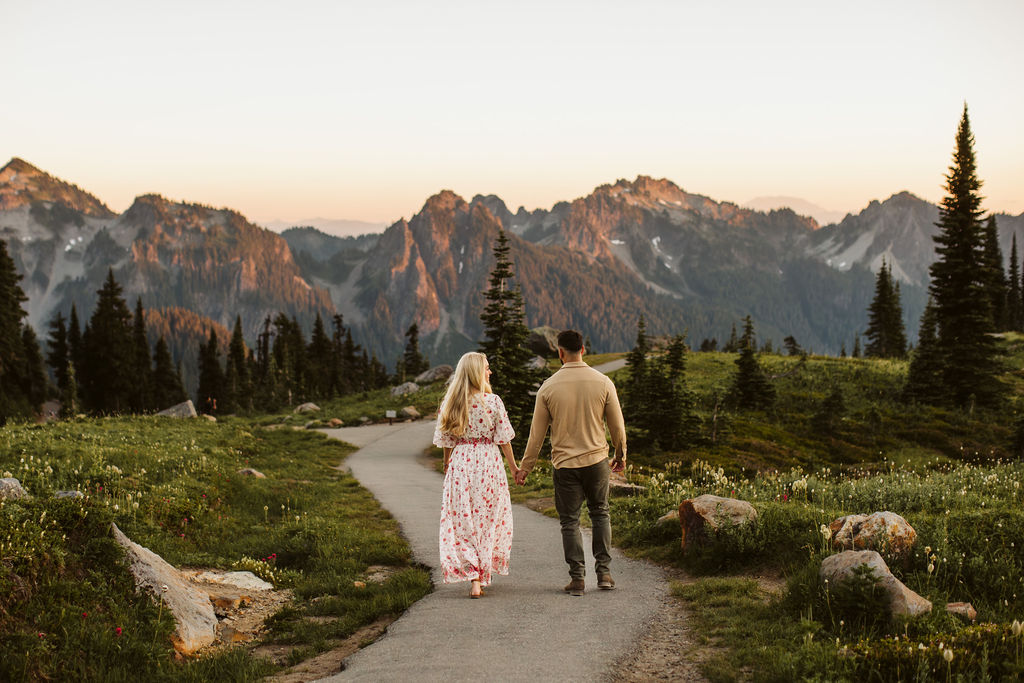 man and woman walk down a gravel path at sunset