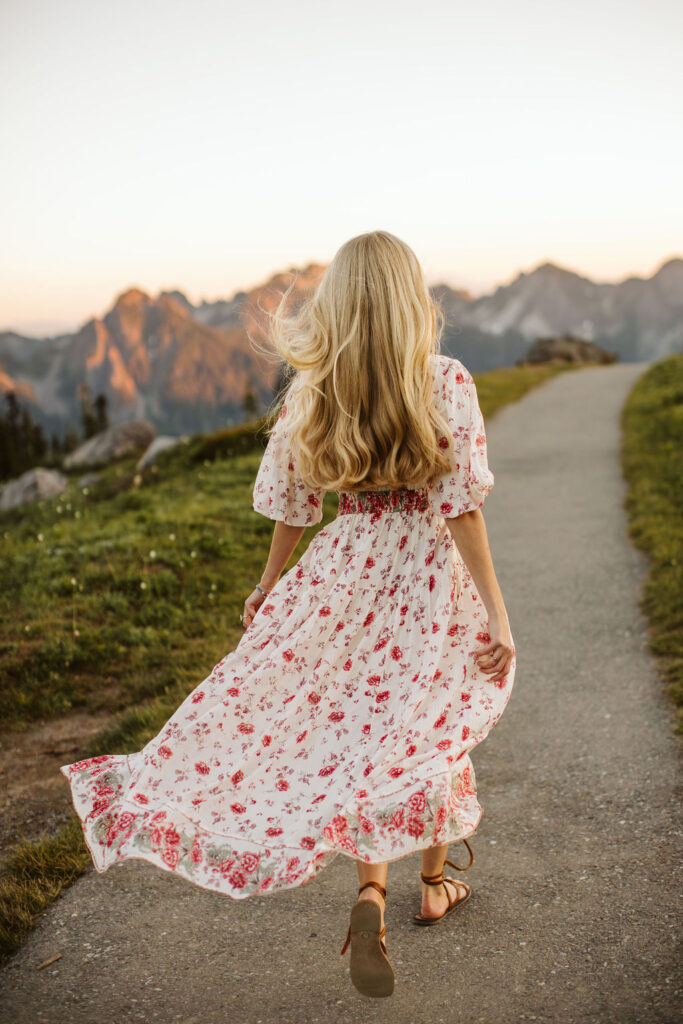 woman walks down path with her dress flaring behind her