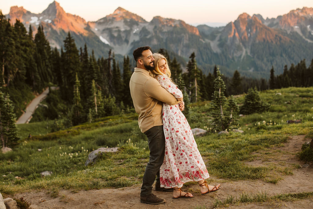 man hugs woman from behind at mt rainier engagement session