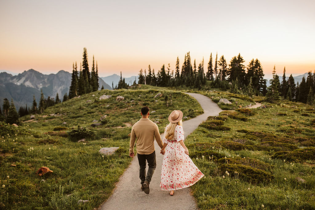 man and woman walk down path at mt rainier engagement session