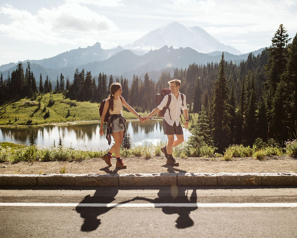 boy and girl walk along road at mt rainier engagement session