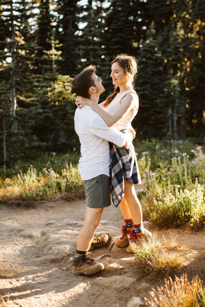 boy and girl walk on path during mt rainier engagement session