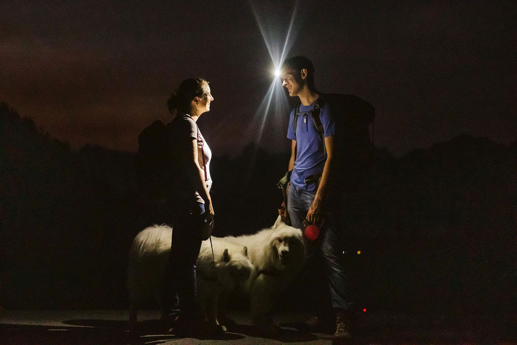 man and woman stand with headlamps 