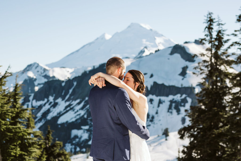 bride and groom hold each other in front of mountain