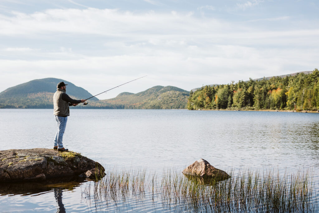 man stands on a rock on the lake